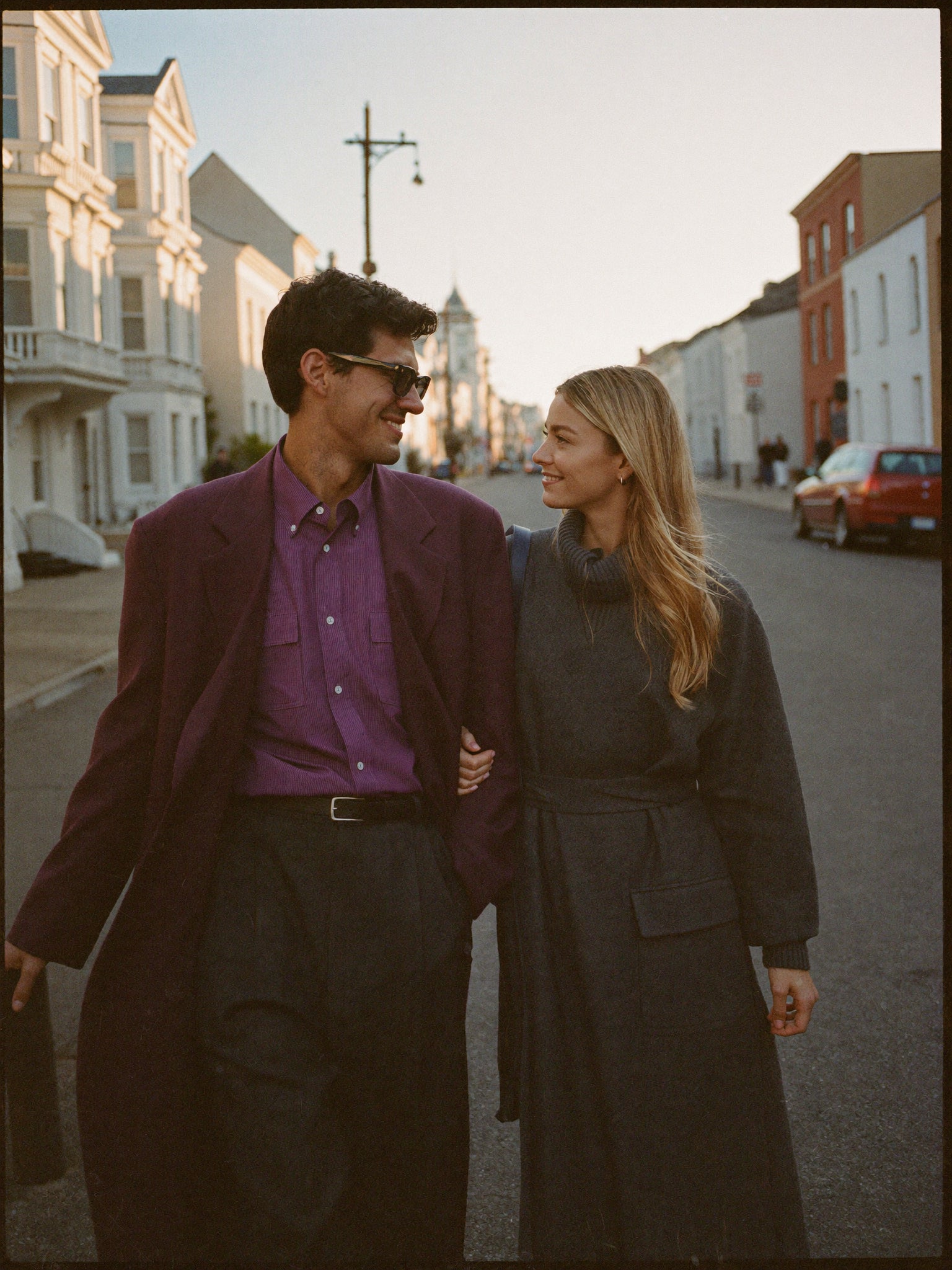 Two friends walking together on an autumn city street, styled in Lila Calloway outerwear and knitwear